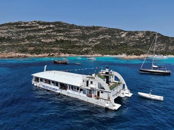 Il catamarano ristorante alla fonda in una baia del nord Sardegna